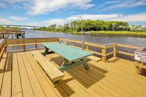 A wooden deck with picnic tables and a sign prohibiting cars, grills, and dogs. - Waterway Landing 205-H (North Myrtle Beach)