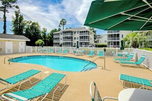 A swimming pool with lounge chairs and a white fence. - Waterway Landing 205-H (North Myrtle Beach)