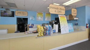 A counter with signs for 'Jolly Mon Beach Store,' 'Portside Pizza & Deli,' and 'Ice Cream.' - Renaissance Tower 908 (Myrtle Beach)
