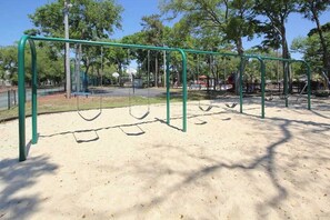 A playground with swings and a basketball hoop. - Renaissance Tower 908 (Myrtle Beach)