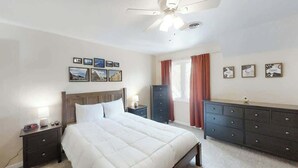 A bedroom with a bed, nightstands, a dresser, and a ceiling fan. - Greystone Condos 203 (Myrtle Beach)