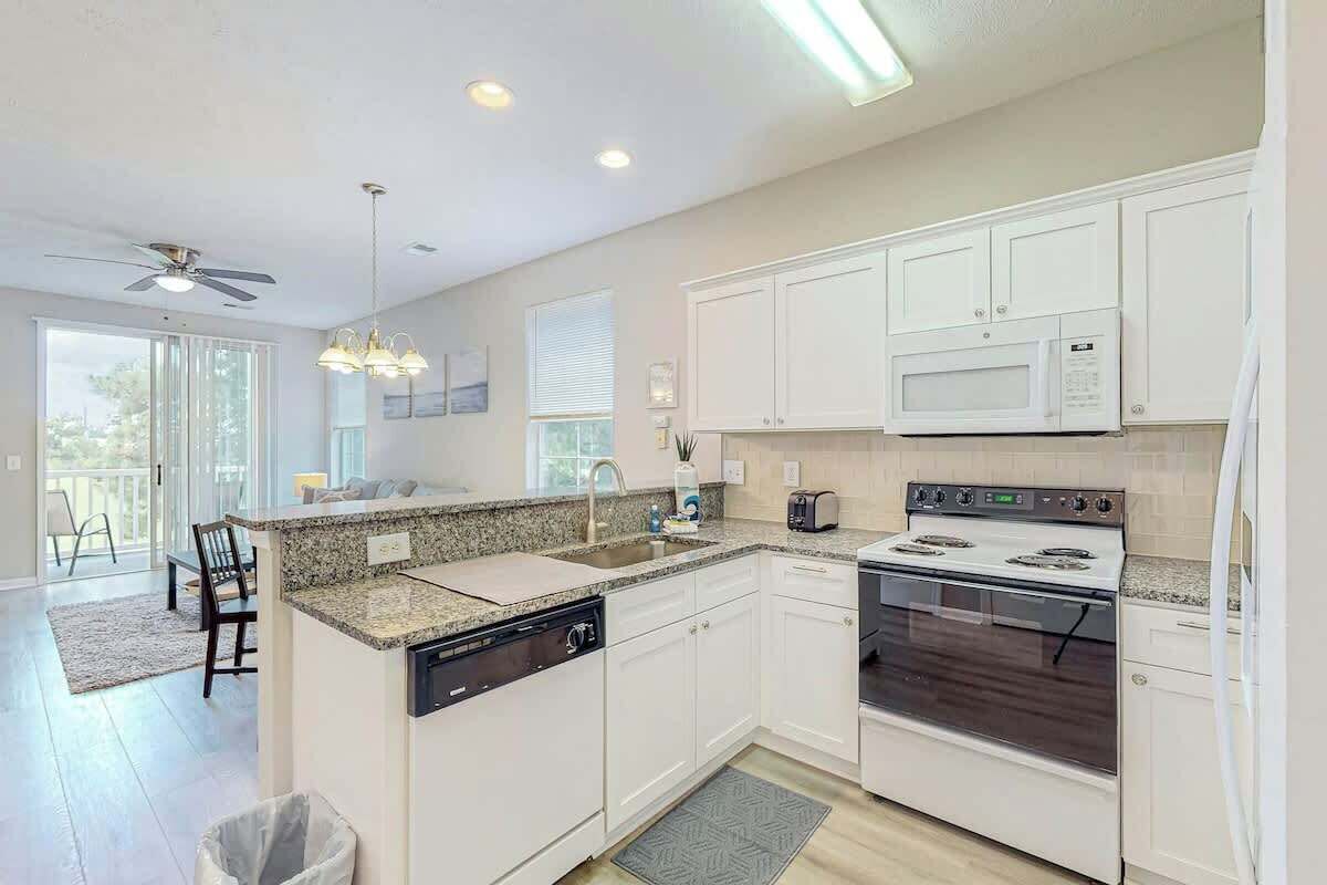 A modern kitchen with white cabinets, a built-in microwave, a stove, and a dishwasher.