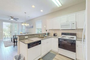 A modern kitchen with white cabinets, a built-in microwave, a stove, and a dishwasher. - Shoreline Serenity at River Oaks (Myrtle Beach)