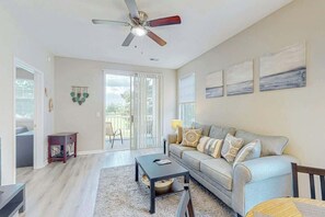 Ein Wohnzimmer mit einer Couch, einem Couchtisch und einem Deckenventilator.