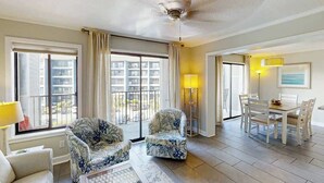 Une chambre d’hôtel avec un balcon, un coin repas et un ventilateur de plafond.