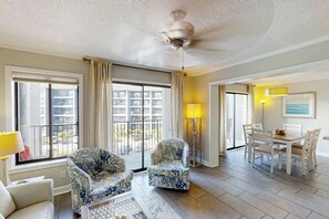 A hotel room with a balcony, a dining area, and a ceiling fan. - Myrtle Beach Resort A-326 (Myrtle Beach)