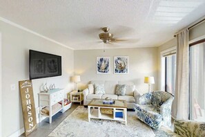 A living room with a sofa, a coffee table, a TV, and artwork on the wall. - Myrtle Beach Resort A-326 (Myrtle Beach)