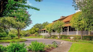 A residential property with a curved driveway, a covered porch, and a well-maintained garden. - Yacht Club Villas 3-505 (North Myrtle Beach)