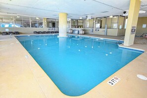 Piscina interior com água cristalina, marcação de profundidade de 90 centímetros e chão revestido de azulejos.