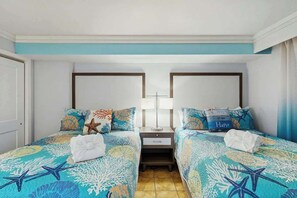 A hotel room with two beds, each with a starfish-themed bedspread, a nightstand with a lamp, and a window with curtains. - Cast a Wave, Unit 352 (Myrtle Beach)