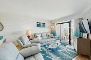 A modern living room with a sofa, a coffee table, and a TV on a stand. - Cast a Wave, Unit 352 (Myrtle Beach)