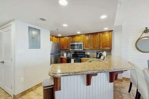 A kitchen with granite countertops, stainless steel appliances, and wooden cabinets. - Cast a Wave, Unit 352 (Myrtle Beach)