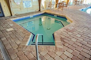 Ein Hallenbad mit gefliestem Boden und einer Badeleiter.