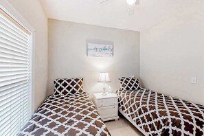 Ein Schlafzimmer mit zwei Betten, einem Nachttisch und einem Wandbild.