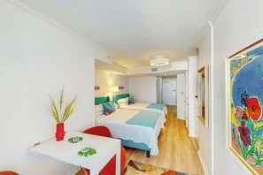 A hotel room with two beds, a small table with a red vase, and a painting on the wall. - Club Wyndham Unit 521 (North Myrtle Beach)