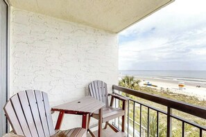 A balcony with a view of the beach, a table, and two chairs. - Shoreham Towers Unit 3-B (North Myrtle Beach)