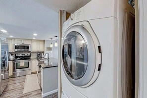 A modern kitchen with stainless steel appliances, a built-in oven, and a large window. - Shoreham Towers Unit 3-B (North Myrtle Beach)