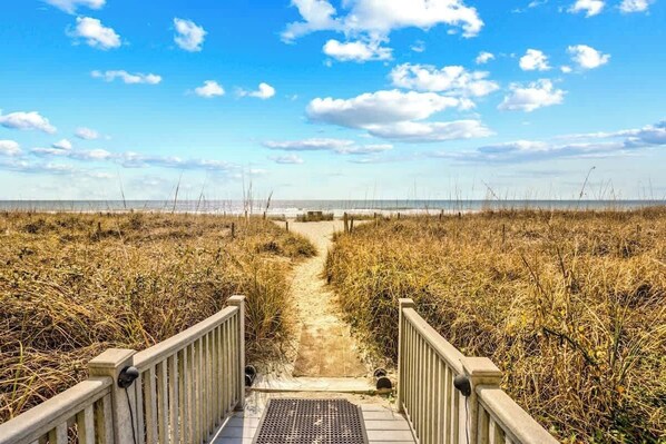A pathway leading to a beach with a wooden railing on both sides. - Shoreham Towers Unit 3-B (North Myrtle Beach)