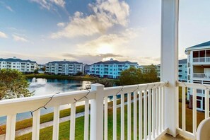 A view from a balcony overlooking a lake with buildings in the background. - Lakefront Waterview Retreat (Myrtle Beach)