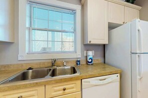 A kitchen with a double sink, a dishwasher, and a refrigerator. - Lakefront Waterview Retreat (Myrtle Beach)