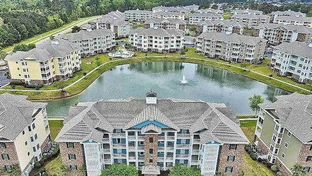 Un edificio residencial de varios pisos con un patio central y una fuente.