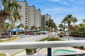 A hotel with a pool, palm trees, and a parking lot. - Sunny and Ready Retreat (Myrtle Beach)