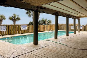 An outdoor swimming pool with wooden pillars and a wooden fence. Signs indicate shallow water and no diving. - Windy Village Unit C-2 (North Myrtle Beach)