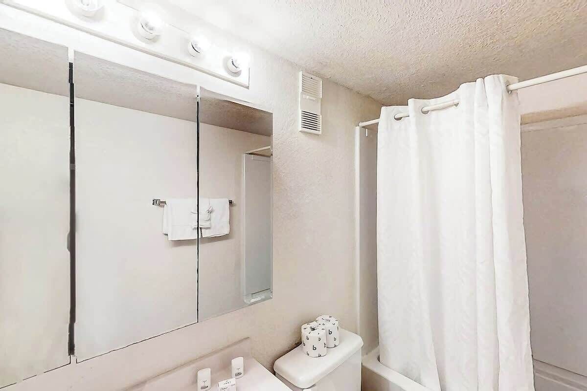 Ein Badezimmer mit Waschbecken, Toilette und Duschvorhang.