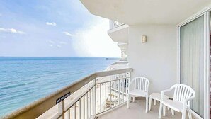 A balcony with a view of the ocean, white plastic chairs, and a 'NO SMOKING' sign. - Water's Edge Resort 1002 (Murrells Inlet)