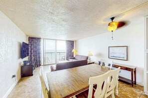 Une pièce comprenant une table à manger, des chaises, un canapé, un téléviseur et un ventilateur de plafond.