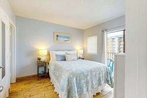 Un dormitorio con cama, lámparas de noche, un cuadro en la pared y una ventana con persianas.