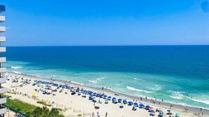 A beach with umbrellas and people, a clear sky, and the ocean. - Ocean View Escape Retreat (Myrtle Beach)