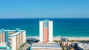 A high-rise hotel with a view of the ocean, featuring multiple balconies and a prominent central tower. - Ocean View Escape Retreat (Myrtle Beach)