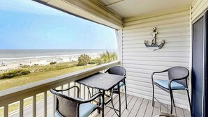 A balcony with a view of the beach, a table, two chairs, and an anchor decoration. - Ocean Forest Villas E-308 (Myrtle Beach)