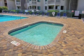 A swimming pool with a tiled deck and lounge chairs. - Ocean Forest Villas E-308 (Myrtle Beach)