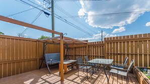 Eine Terrasse im Freien mit einer Schaukel, einem Tisch und Stühlen.