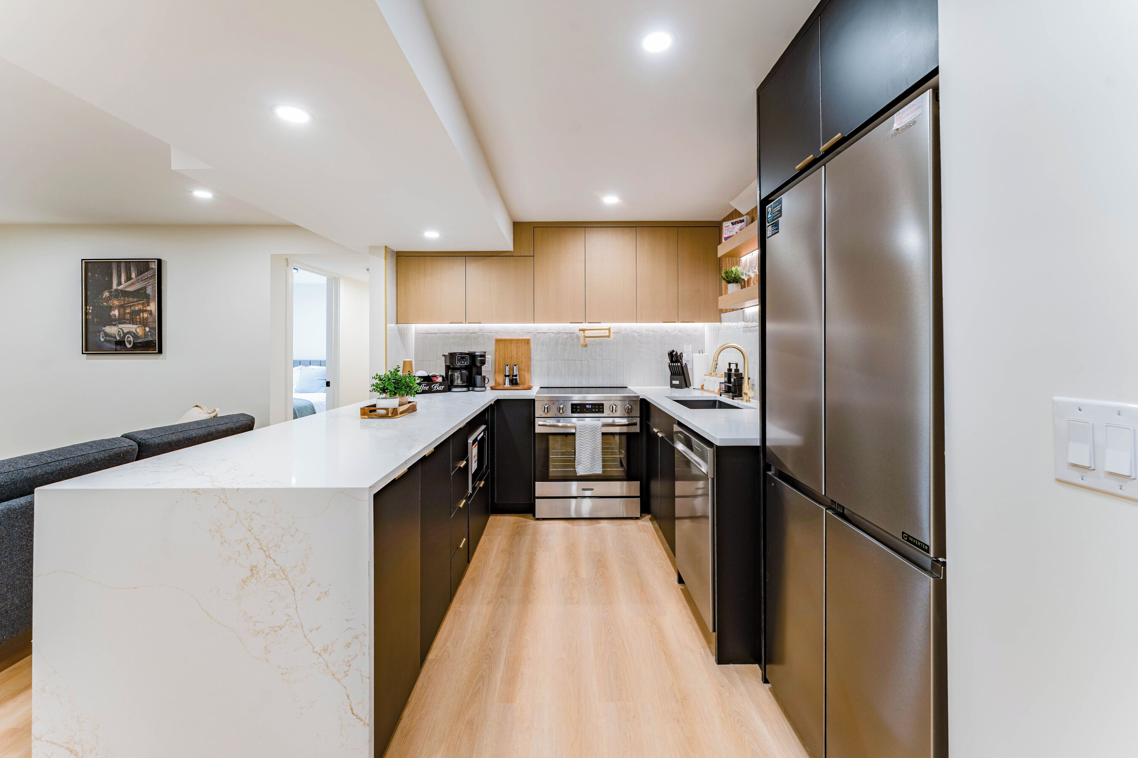 Una cocina moderna con una isla central, electrodomésticos de acero inoxidable y armarios de madera.