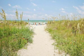 A sandy pathway leading to a beach with ocean in the background. - Emerald Pointe Unit 1-C (North Myrtle Beach)