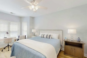 A bedroom with a bed, bedside tables, a desk, and a ceiling fan. - Magnolia Escape Retreat (Myrtle Beach)