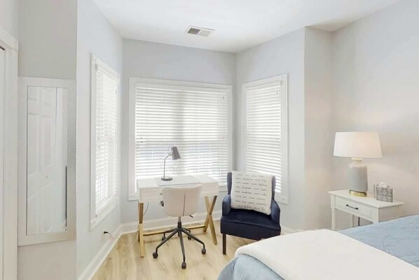 A bedroom with a bed, a desk, a chair, and a nightstand. - Magnolia Escape Retreat (Myrtle Beach)