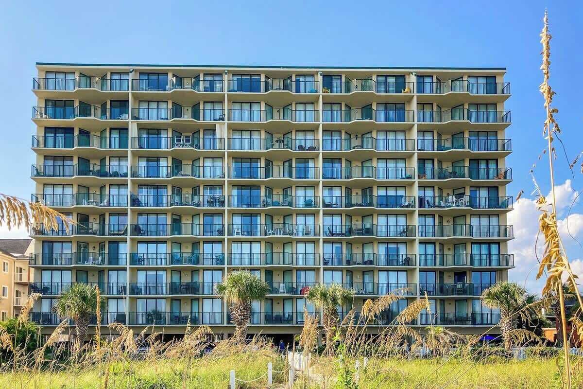 A multi-story hotel with balconies, a flat facade, and a clear sky.
