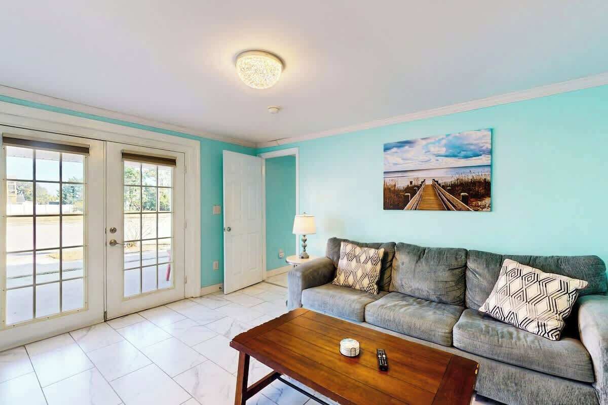 A living room with a sofa, a coffee table, and a painting on the wall.