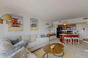 A living room with a sofa, coffee table, and artwork on the wall. - The Beach House at Palace Resort 1911 (Myrtle Beach)