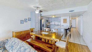 Un espacio habitable compacto con kitchenette, comedor y dormitorio.