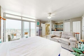 A spacious room with a balcony, a sofa, a dining area, and a kitchen. - Bay Watch Resort 1901 Oceanview (North Myrtle Beach)