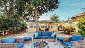 A patio area with wicker furniture, a fire pit, and a house in the background. - Flamingo House 2 - top (North Myrtle Beach)