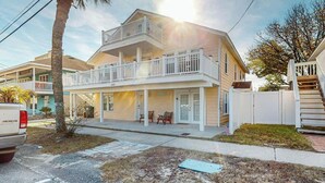 A two-story residential building with a balcony, a front porch, and a garage. - Flamingo House 2 - top (North Myrtle Beach)