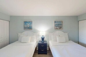 A twin room with two beds, a nightstand, and artwork on the walls. - Bay Watch Resort 0315 (North Myrtle Beach)