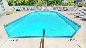 A rectangular swimming pool with a metal safety railing in the foreground. - Legends Resort at Myrtle Beach Unit F (Myrtle Beach)