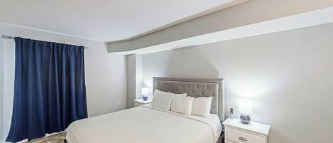 Ein Schlafzimmer mit einem Bett, Nachttischen und einer Lampe.